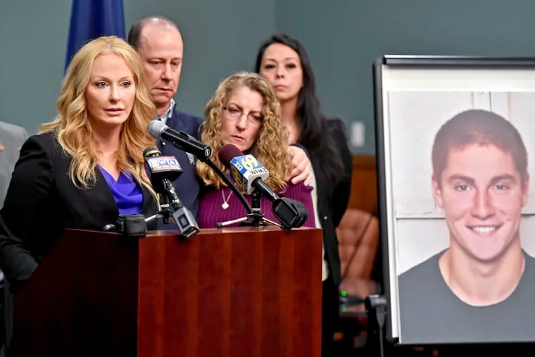 In this May 5, 2017, file photo, former Centre County District Attorney Stacy Parks Miller, left, announced findings in an investigation into the death of Penn State University fraternity pledge Tim Piazza, seen in photo at right, as his parents, Jim and Evelyn Piazza, second and third from left, stand nearby during a news conference in Bellefonte.