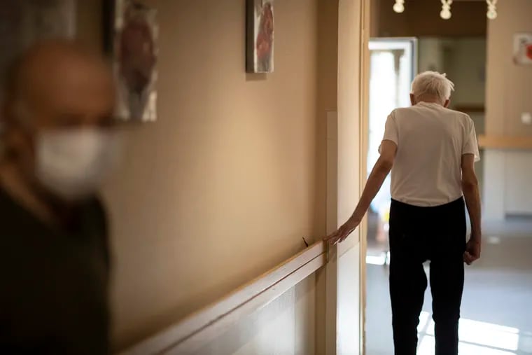 FILE - In this April 16, 2020, file photo, Richard Eberhardt walks along a corridor at a nursing home in Kaysesberg, France. Countries across Europe are struggling amid the coronavirus pandemic with the dilemma of leaving the elderly and others near death in enforced solitude or whether to allow some personal contact with relatives. At nursing homes, everything is done to keep out visitors who might be infected, and family members are almost always banned from coming to see their loved ones. (AP Photo/Jean-Francois Badias, File)