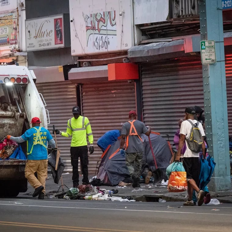 Sanitation workers clear trash as people are relocated from an encampment on Kensington Avenue in Philadelphia in May. The state trust overseeing spending of opioid settlement funds recently approved some spending to revitalize the neighborhood after rejecting it earlier this summer.