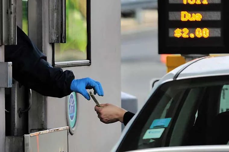 A Burlington Bristol Bridge toll collector collects the $2.00 bridge toll from a motorist on March 5, 2010.  Toll collecting on both bridges is on the NJ side of the river. ( Elizabeth Robertson / Staff Photographer )