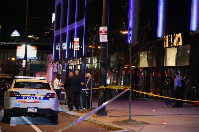 Police investigate the scene where multiple people were shot outside the Golf & Social bar on the 1000 block of North Delaware Avenue in Philadelphia's Fishtown section on March 26. Police have arrested a 16-year-old in connection with the incident.