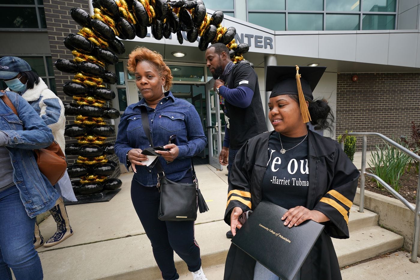 Laila Manigo (front right), with her diploma on campus at Community College of Philadelphia, her mother, Linette Rucker (back center), and her father, Juan Manigo, (back center) after a ceremony at CCP, where Laila received her associate's degree. The Parkway Center City Middle College student will receive her high school diploma on June 9.