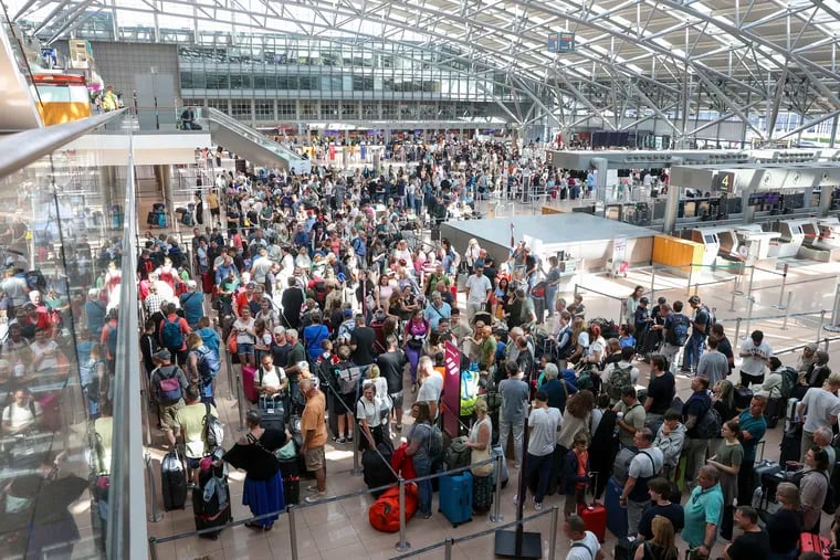 Travelers wait in Terminal 1 for check-in at Hamburg Airport, in Hamburg.