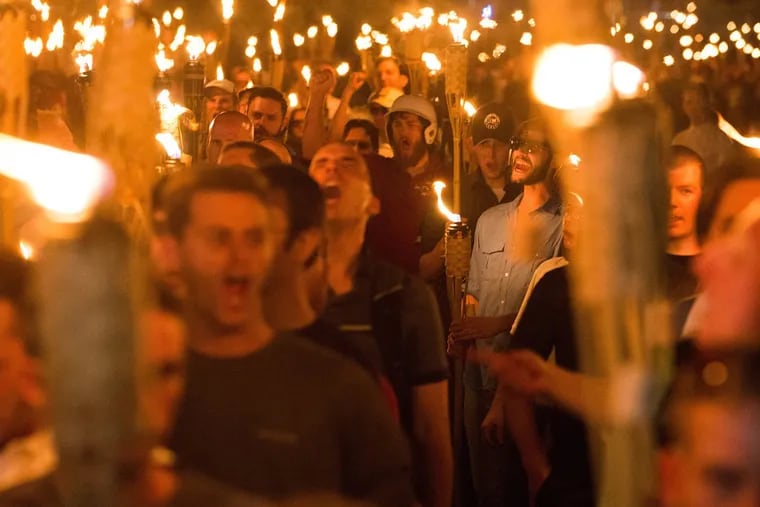 Neo-Nazis, alt-right, and white supremacists march the night before the 2017 "Unite the Right" rally through the University of Virginia in Charlottesville, Va.