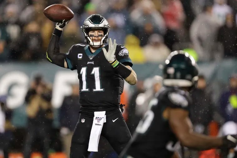 Eagles quarterback Carson Wentz aims a fourth-quarter pass toward running back Boston Scott during Monday night's comeback.