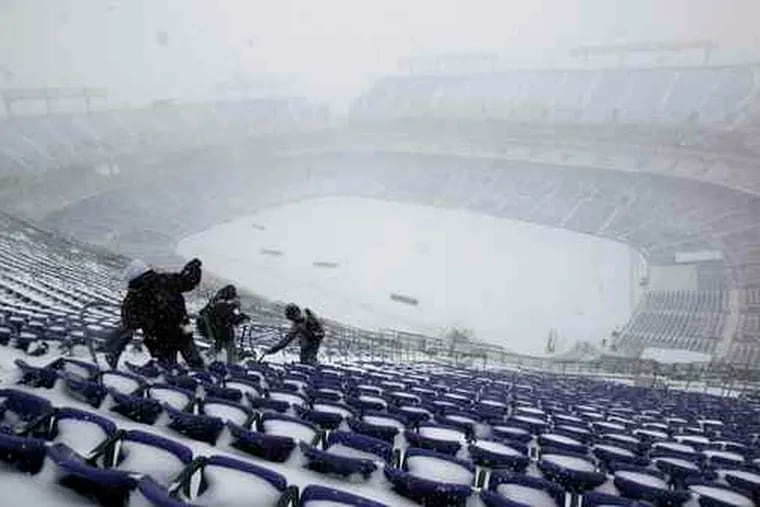At M&T Bank Stadium in Baltimore, workers remove snow in preparation for a Ravens-Chicago Bears football game today.