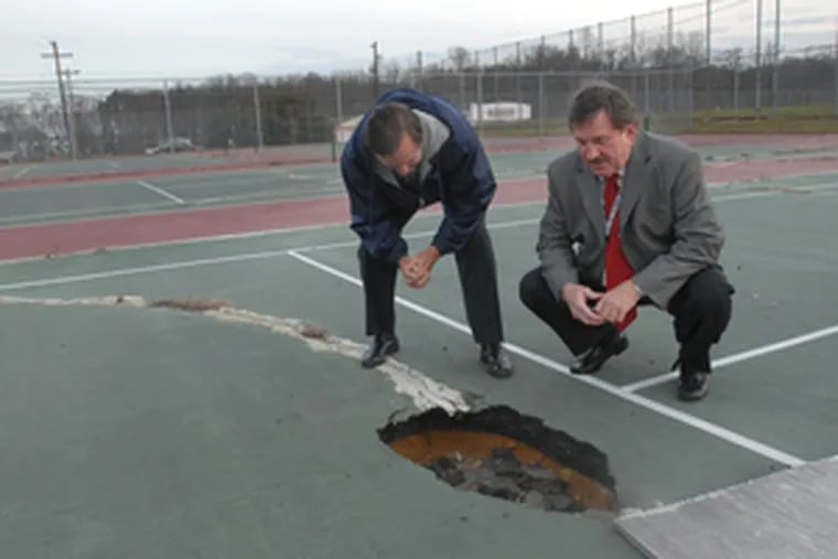 This tennis court at Highland Regional High in Blackwood isn&#0039;t fit to use. Ralph Ross (right), Black Horse Pike superintendent, and buildings supervisor Bill Collins hope a state aid proposal helps.