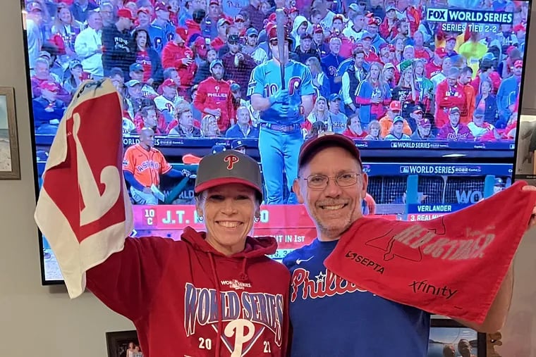 Jennifer Gotthelf and Jason Klingele, husband and wife from Moorestown, cheer on the Phillies at home. They couldn't swing World Series ticket prices, a fact that Gotthelf found frustrating.