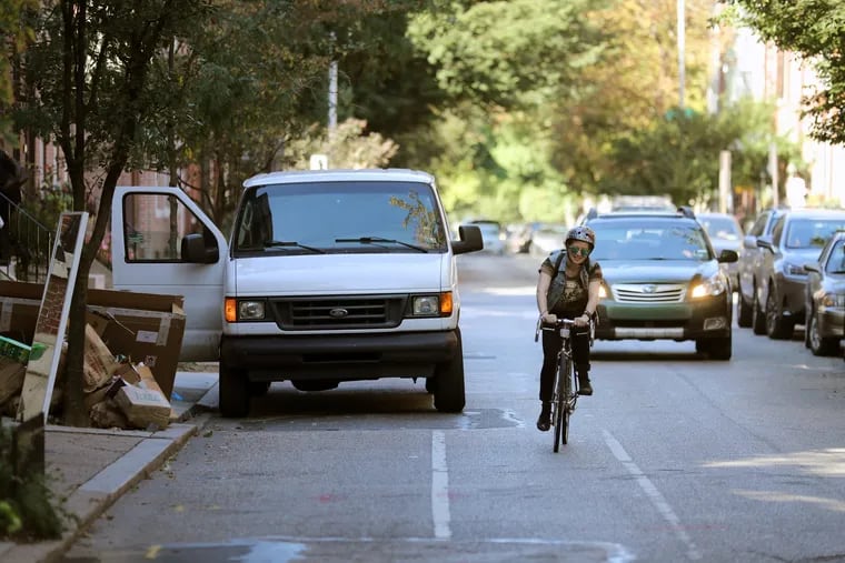 Cyclists have to verge into traffic as the bike lane is blocked by work vans and delivery trucks on Pine Street, between 18th and 22nd Streets in 2017.