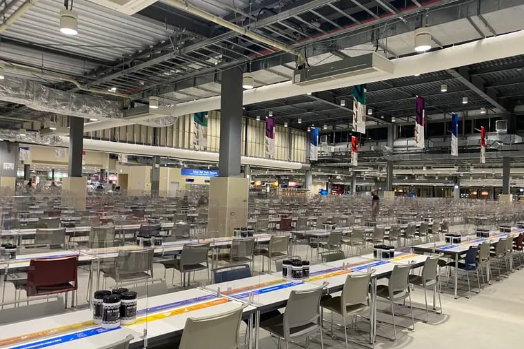 The athletes' dining hall in Tokyo, with eating stations separated by plastic glass.