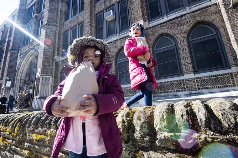 Historians say the coronavirus pandemic may reshape public support for government programs that provide guaranteed income, social support, and medical care. Here two Philadelphia children pick up bagged breakfast and lunches last week outside the Tilden Middle School.