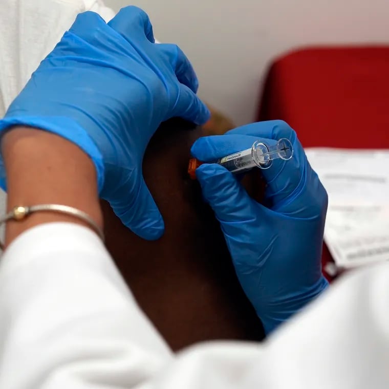 A pharmacist administers a COVID-19 vaccine at a pharmacy in New York.