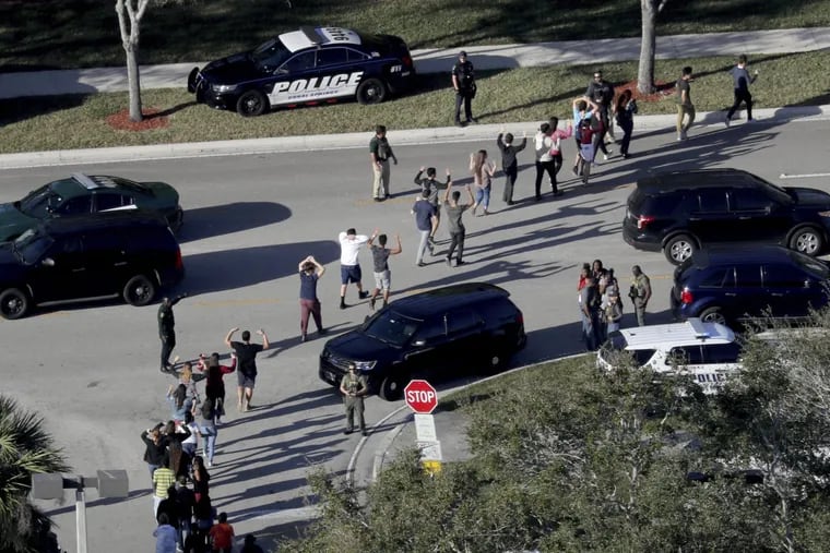 Students evacuate Marjory Stoneman Douglas High School in Parkland, Fla. on Feb. 14, 2018 after a gunman killed 17 people at the school.
