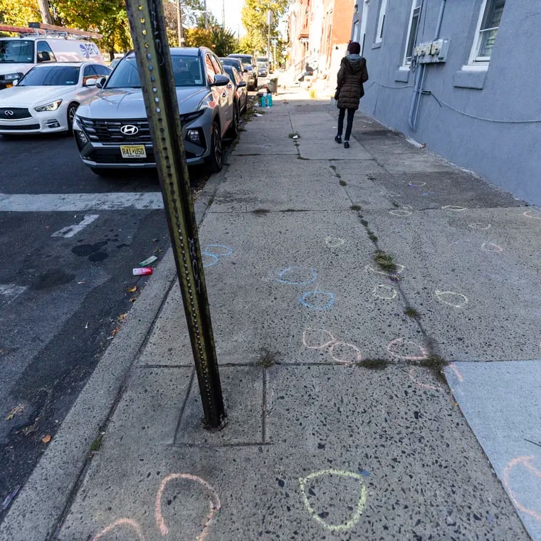 Chalk circles mark where bullet casings fell during two drive-by shootings early Saturday morning in North Philadelphia's Hartranft neighborhood, near Cumberland and 11th Streets, where seven people were wounded, two critically.