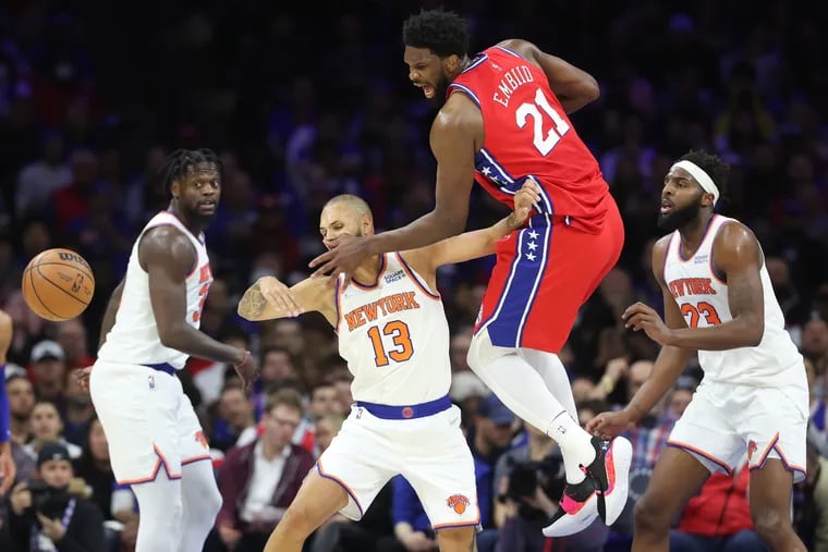 The Sixers' Joel Embiid has the ball stripped away by the Knicks' Evan Fournier (second from left) on Wednesday night.