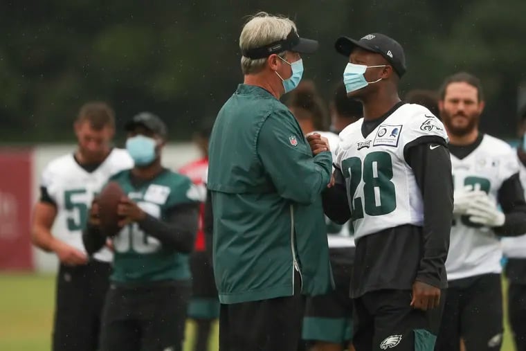 Eagles safety Will Parks (right) greets Eagles head coach Doug Pederson at a recent practice. Parks is sidelined with an injury.