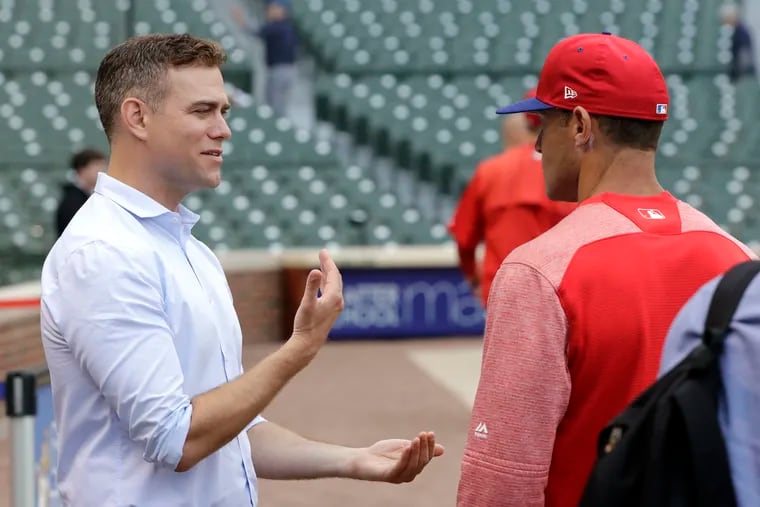 Theo Epstein (left) talked with former Phillies manager Gabe Kapler before a game at Wrigley Field in 2018.