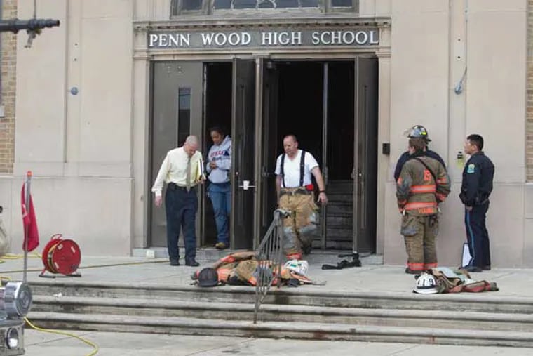 An overnight fire at Lansdowne's Penn Wood High School forced officials to cancel classes Thursday. Here,officials and fire personnel exit the school after evaluating damage ( ED HILLE / Staff Photographer )
