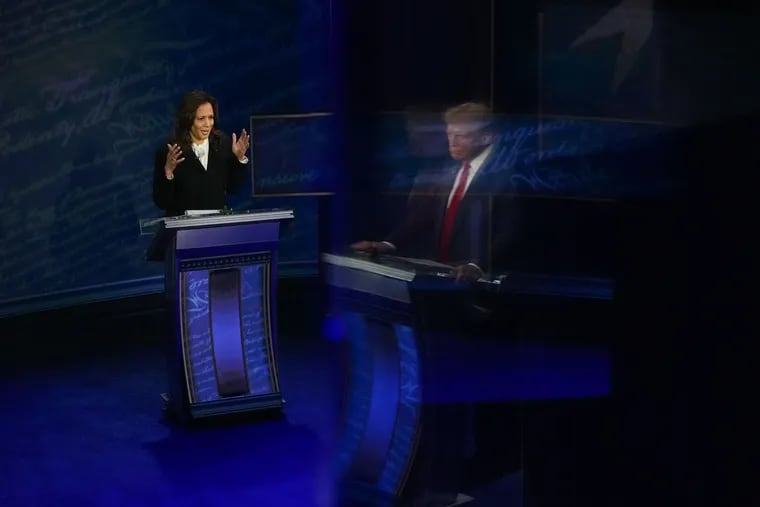 Former President Donald Trump, reflected on a wall, and Vice President Kamala Harris during the presidential debate at the National Constitution Center on Tuesday.