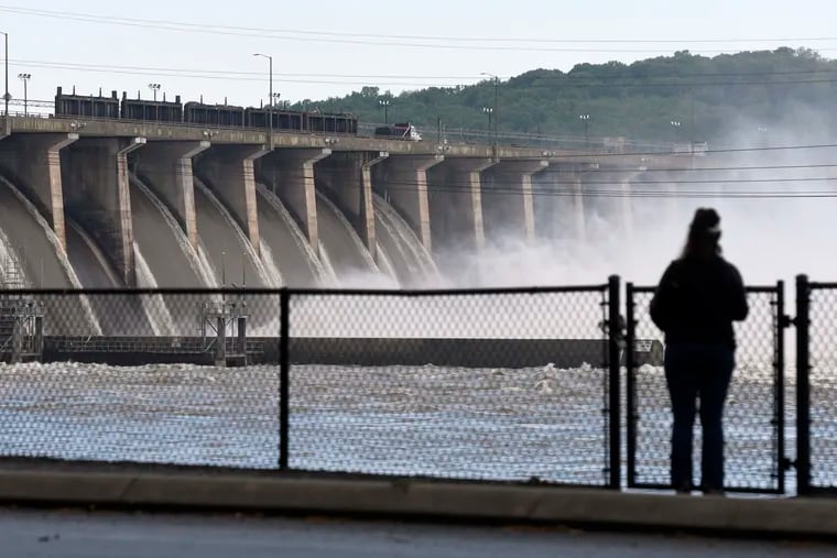A woman stands near Conowingo Dam, a hydroelectric dam spanning the lower Susquehanna River near Conowingo, Md., on Thursday, May 16, 2019. Officials once counted on the dam to block large amounts of sediment in the Susquehanna from reaching Chesapeake Bay, the nation's largest estuary, but the reservoir behind the dam has filled with sediment far sooner than expected.