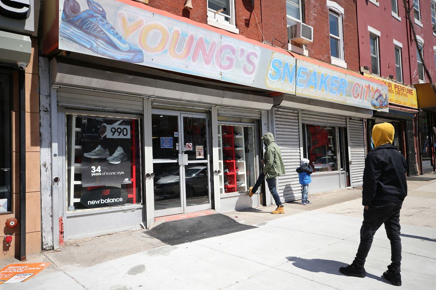 Customers wait outside to shop at Young's Sneaker City. The store only allows six customers in the store at a time because of COVID-19 restrictions.