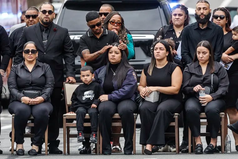 Family members watch the Commander's March to a public viewing for Philadelphia police officer Jaime Roman.