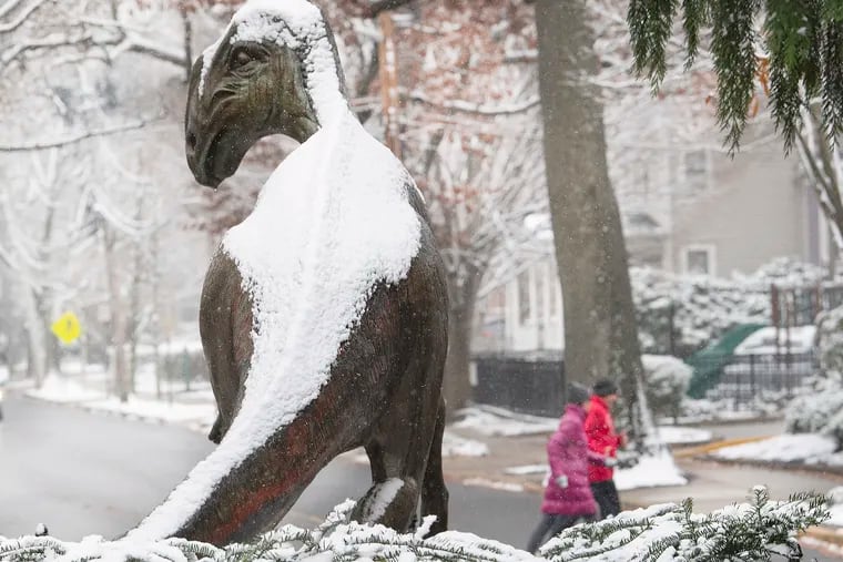 Snow lies on top of a Hadrosaurus statue during a light snow winter scene in Haddonfield on Wednesday.
