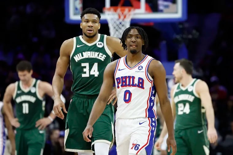 Sixers guard Tyrese Maxey walks past Milwaukee Bucks forward Giannis Antetokounmpo (34) during their Feb. 25 game at the Wells Fargo Center.