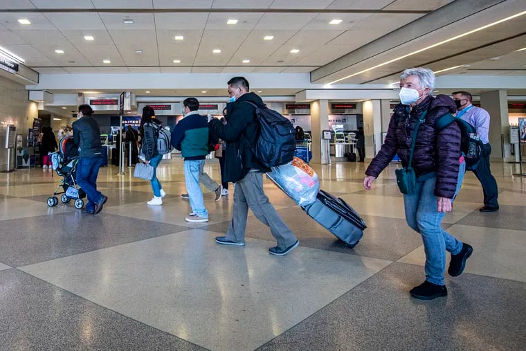 People travel through the Philadelphia International Airport on Tuesday, when masks were required by the city.