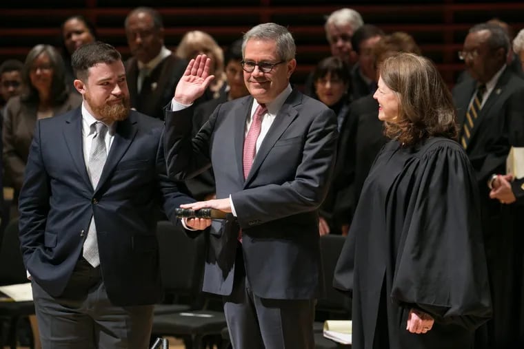 Larry Krasner takes the oath off office from his wife, Philadelphia Common Pleas Court Judge Lisa M. Rau, at the Kimmel Center, as their son, Nathan, holds a Bible. Afterward, some in the audience chanted, "Lar-ry! Lar-ry!"