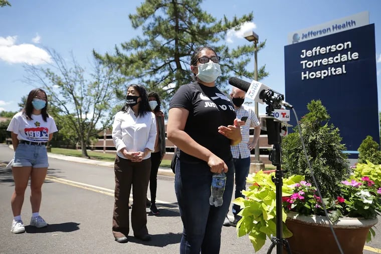 Claudia Martinez (right) talked about her uncle as she stood outside Jefferson Health Torresdale Hospital in Philadelphia on June 24, 2020. Immigration activists say Jefferson Health sought to “medically repatriate” an undocumented Guatemalan man with a serious brain injury in an effort to rid itself of his care. City Councilwoman Helen Gym is at rear.