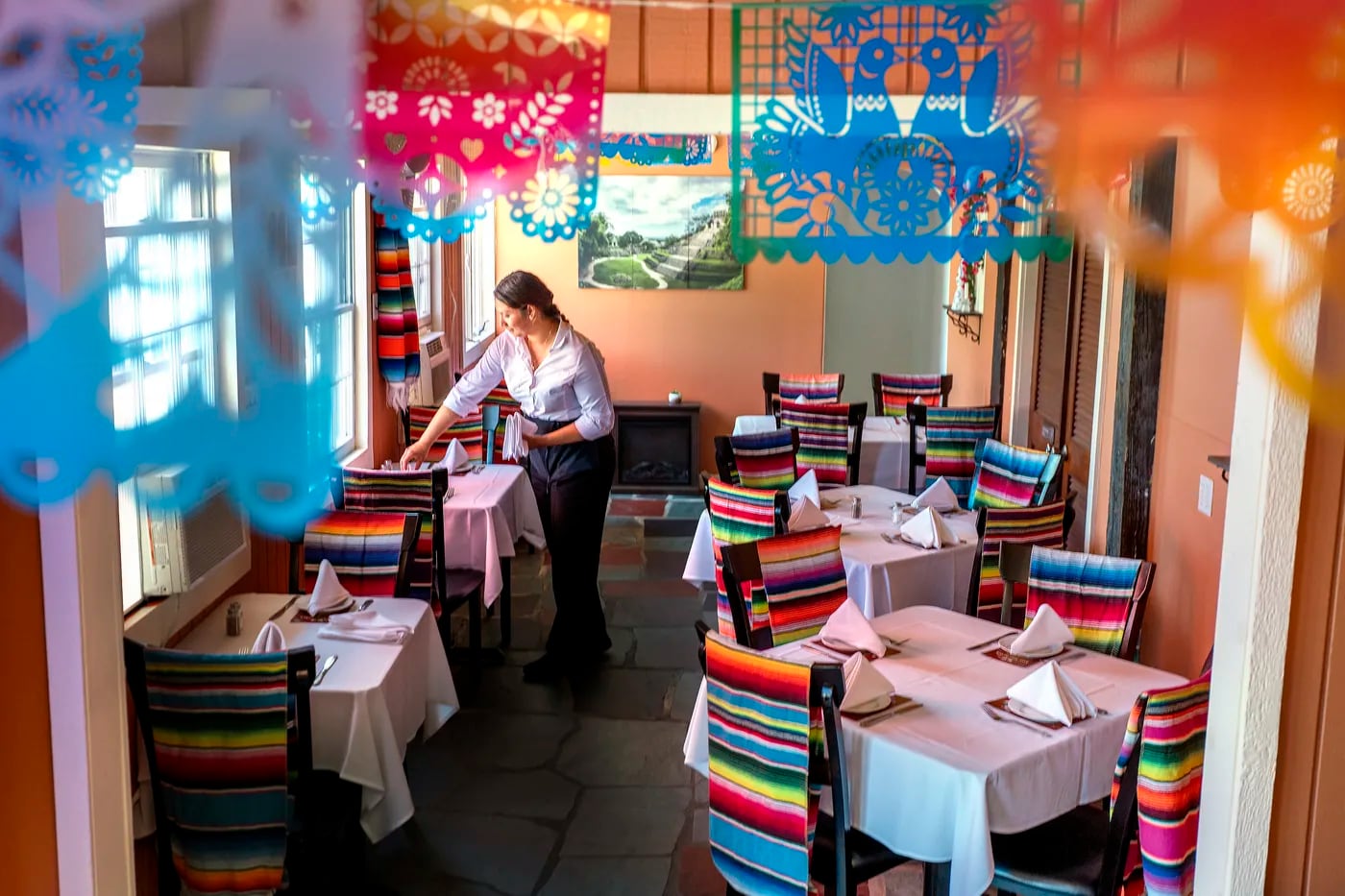 Jessica Eguizabal readies the dining room, a festive and colorful space, at Los Machetes.