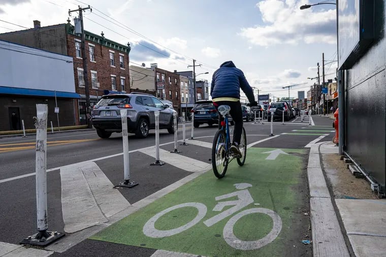 A cyclist travels along Washington Avenue near Ninth Street in Philadelphia, Pa. One year after the completion of the Washington Avenue Improvement Project, the city has released a report about how the traffic calming/street layout measures reduced illegal parking while increasing safety and bus ridership.