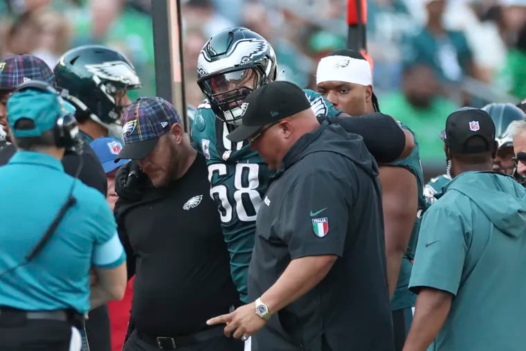 Jordan Mailata is helped off the field by Eagles personnel after injuring his hamstring on Sunday vs. the Browns.