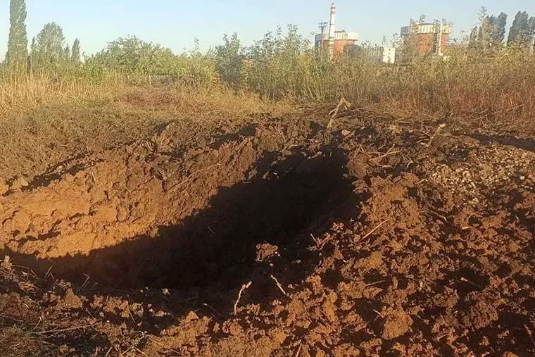 In this photo provided by the South Ukraine nuclear power plant, a crater left by a Russian rocket is seen 300 meters from the nuclear power plant, in the background, close to Yuzhnoukrainsk, Mykolayiv region, Ukraine.