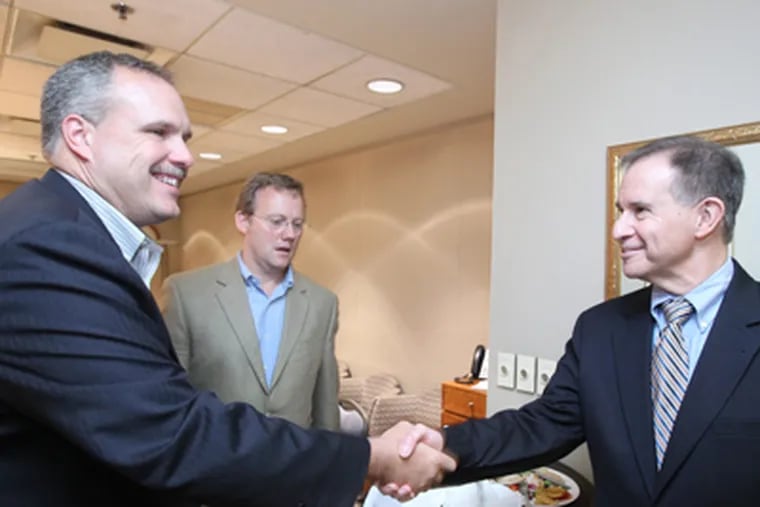 Jim Gratton, left, president of the Hotel Association, and Ed Grose, executive director of the Hotel Association, shake hands with Gregory J. Fox, chairman of the board of the Pennsylvania Convention Center Authority Board. (Charles Fox / Staff Photographer)