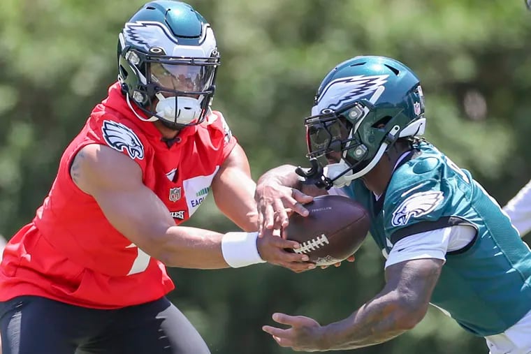 Eagles quarterback Jalen Hurts hands off the ball to D'Andre Swift during OTAs at the NovaCare Complex in Philadelphia on Thursday, June 1, 2023.