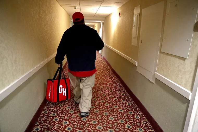 Grubhub delivery person Robert Wold walks into a Rockford, Ill., hotel as he completes a delivery.