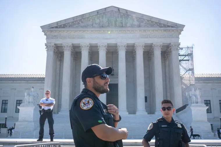 Supreme Court Police officers stand on duty outside of the Supreme Court building.