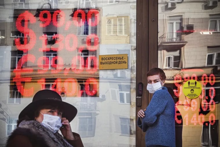 People walk past a currency exchange office in central Moscow on Monday, Feb. 28, 2022. The Russian ruble collapsed against the dollar and the euro on the Moscow Stock Exchange on Feb. 28 as the West punished Moscow with harsh new sanctions over the Kremlin's invasion of Ukraine. (Alexander Nemenov/AFP/Getty Images/TNS)