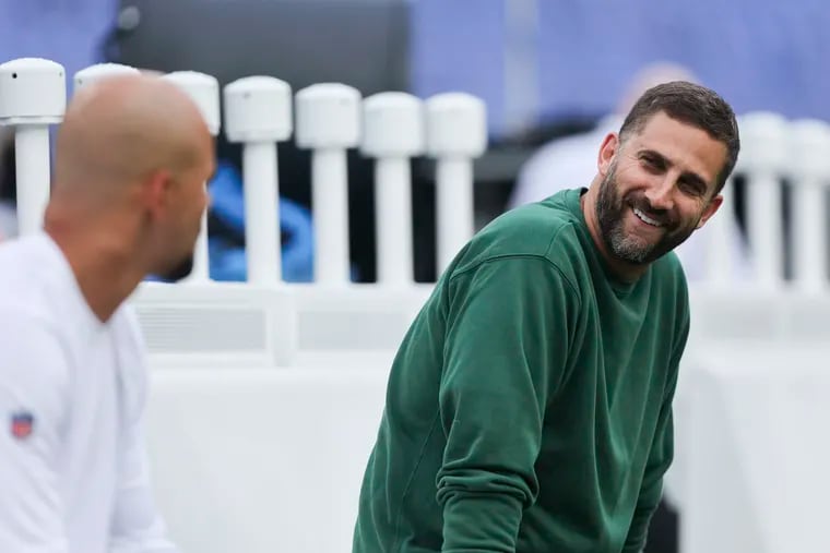 Eagles coach Nick Sirianni with linebacker Zack Baun (left) before the preseason game against the Ravens. Players say they have noticed changes to Sirianni's coaching approach.