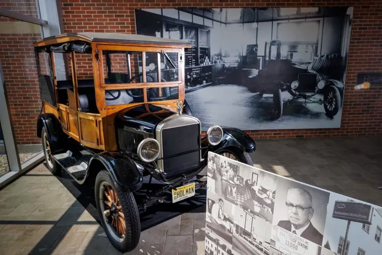 A Ford Model T on display in the lobby of the Holman Automotive Group office in Maple Shade. In the foreground is a portrait of founder Steward Holman.