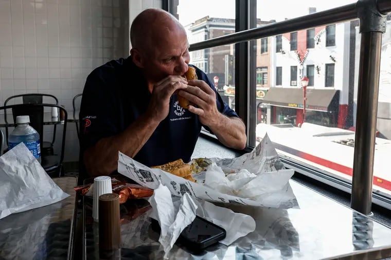 David Griggs takes a bite of a steak sandwich at Jim's Steaks at Fourth and South Streets.