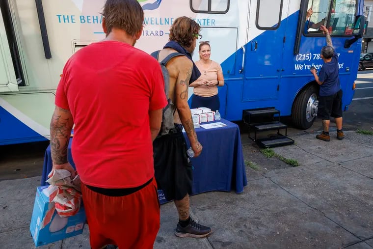 In this 2023 file photo, people along Kensington Avenue walk past the mobile home belonging to the Behavioral Wellness Center at Girard parked along Kensington Avenue. The Behavioral Wellness Center at Girard parked their Winnebago along Kensington Avenue to assist those living with addiction find inpatient and outpatient care.