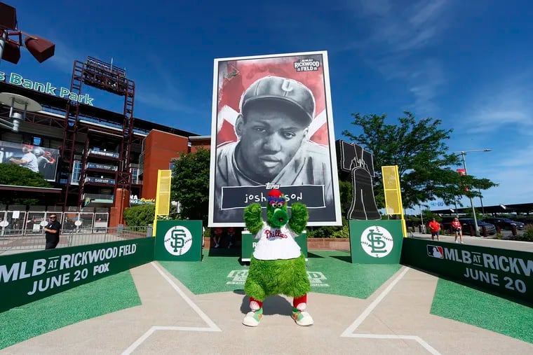 The Phillie Phanatic poses in front of the giant Topps trading card honoring Negro Leagues legend Josh Gibson outside Citizens Bank Park on Saturday.