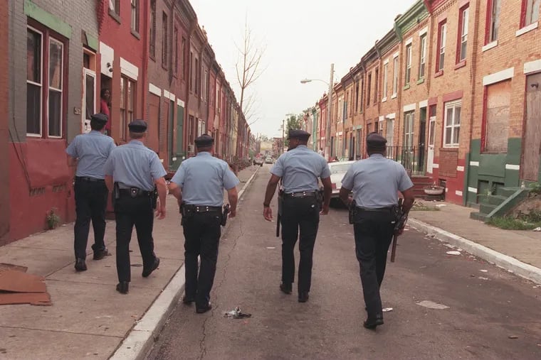 Philadelphia Police officers walk the 2500 block of Stanley Street as part of Operation Sunrise in 1998.