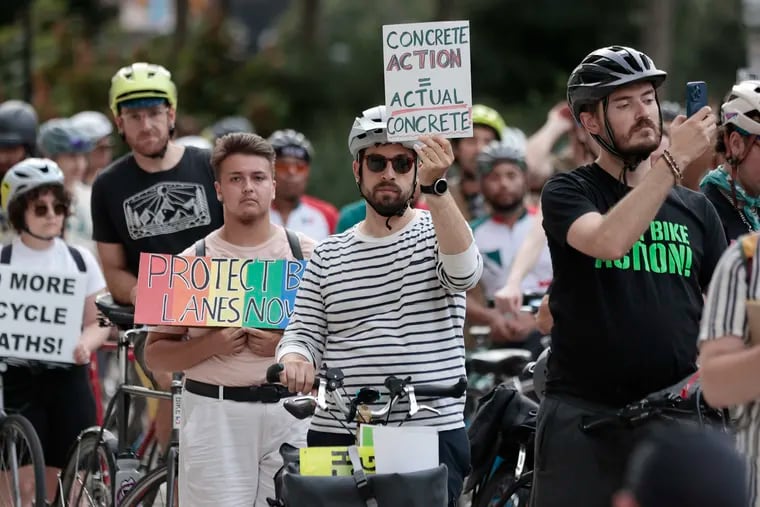 Drew Snyder of Philadelphia wants concrete action for cyclists. Snyder held up his message at City Hall after cyclists biked from the Art Museum to City Hall Friday to protest what they see as a lack of commitment to traffic safety from the mayor.