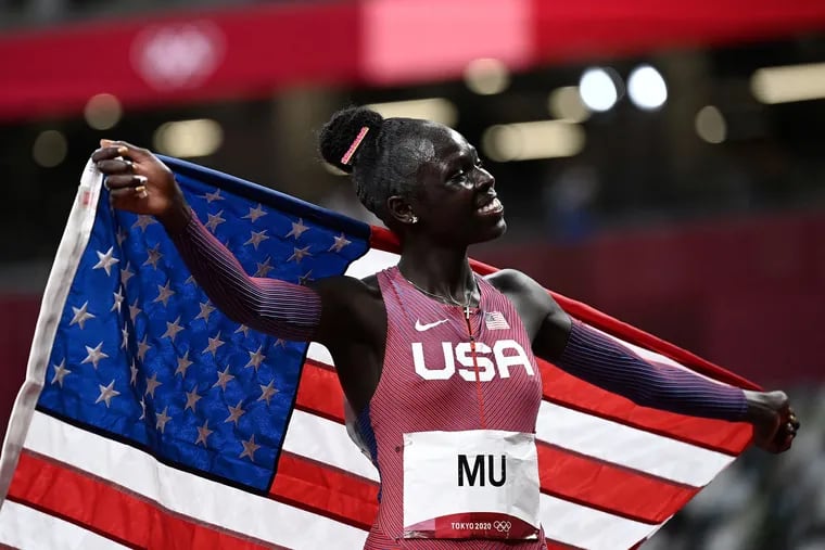 Athing Mu celebrates with an American flag after winning gold in the Olympics women's 800m final.