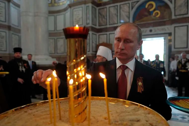 Russian President Vladimir Putin lights a candle in St. Vladimir's Cathedral in Sevastopol. A Victory Day celebration in the Crimean city drew tens of thousands of spectators.