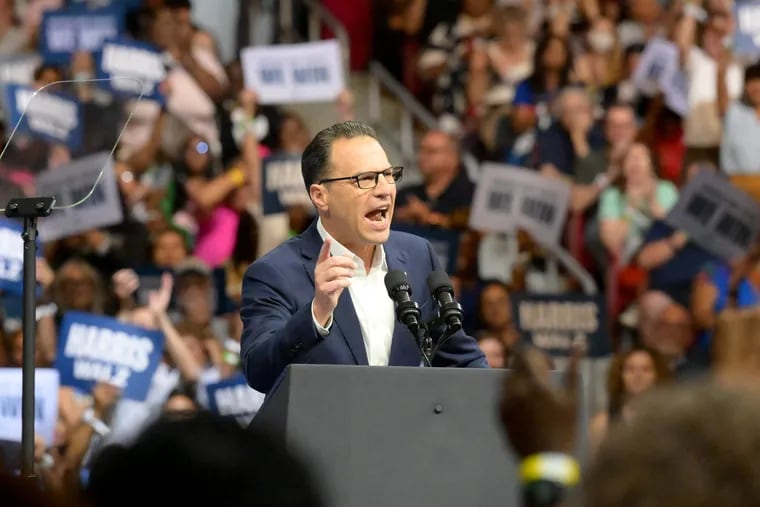 Pennsylvania Gov. Josh Shapiro speaks at the podium ahead of U.S. Vice President Kamala Harris and Minnesota Gov. Tim Walz at a rally at Temple University's Liacouras Center on Tuesday.